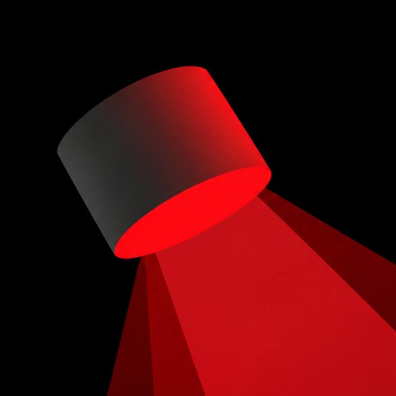 A red spotlight shining into darkness
